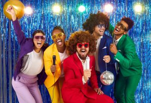 People wearing 70s theme party outfits while posing at the camera