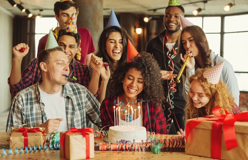25th birthday ideas: people wearing party hats while enjoying a birthday party