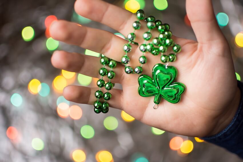 St Patricks Day party: person holding a green clover necklace