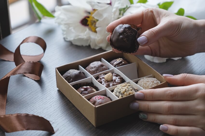 Traditional wedding gifts: person holding a piece of chocolate