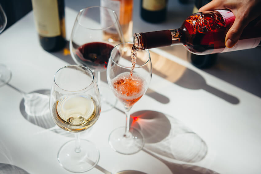Person pouring wine into a wine glass