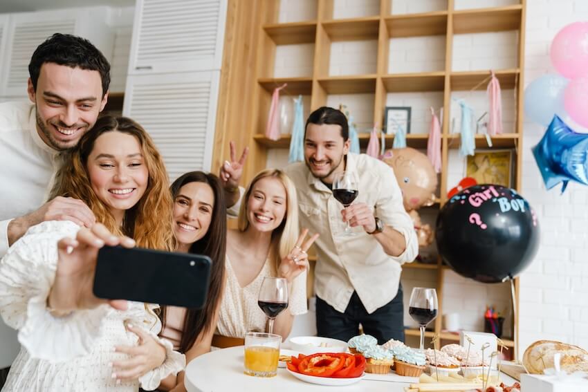 Coed baby shower games: pregnant woman and her friends taking a groufie