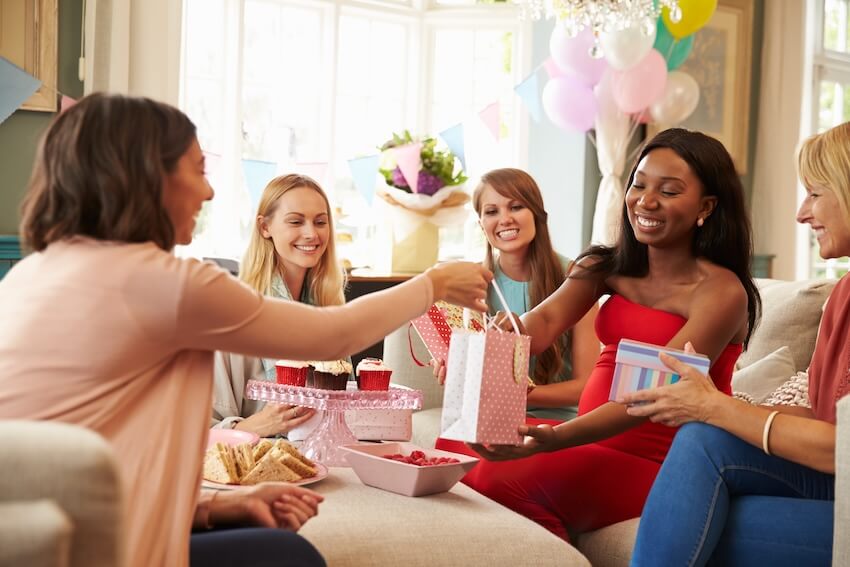 Baby shower card message: pregnant woman receiving gifts from her friends