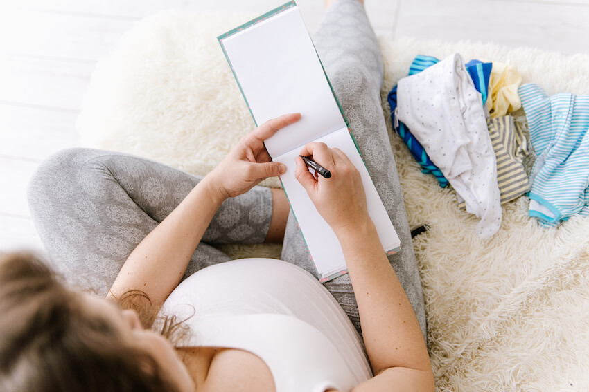 Coed baby shower: pregnant woman writing on a notepad