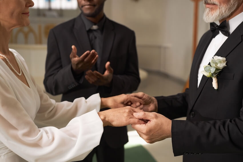 Vow renewal invitations: senior couple holding hands during their wedding vow renewal
