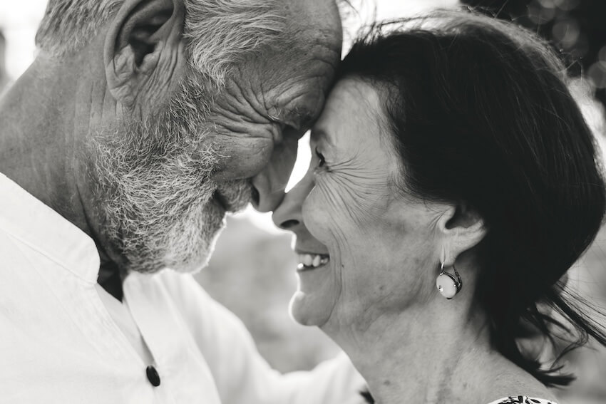 50th anniversary invitations: senior couple touching their foreheads together while smiling