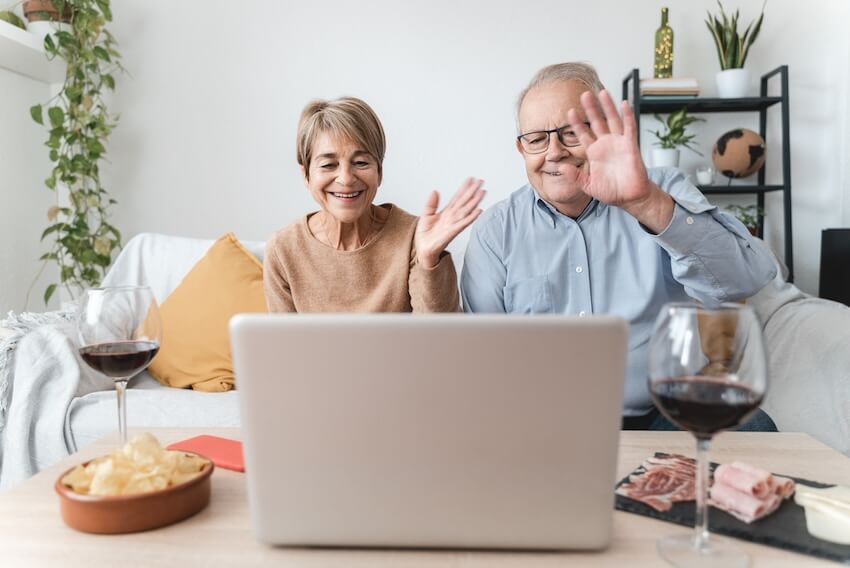 Retirement party: senior couple using a laptop for a video call