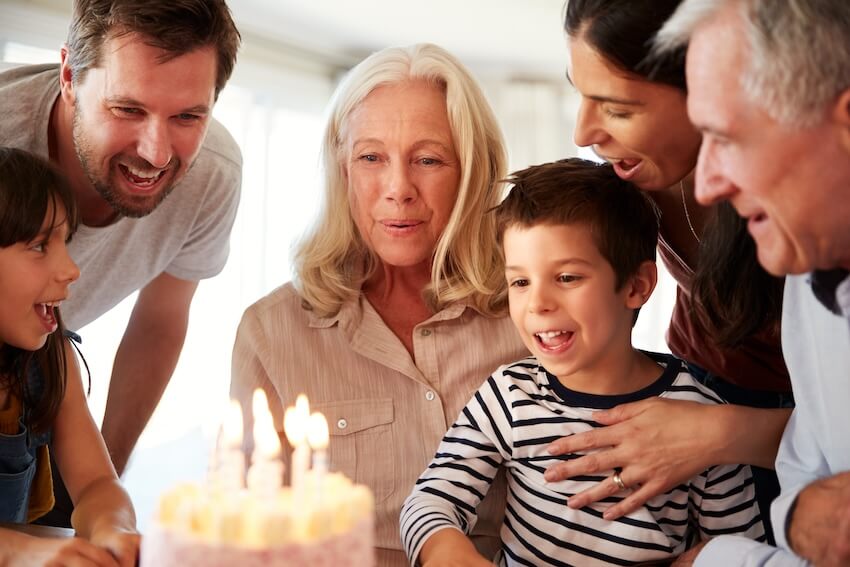 Birthday card ideas for grandma: senior woman blowing out candles on her birthday cake