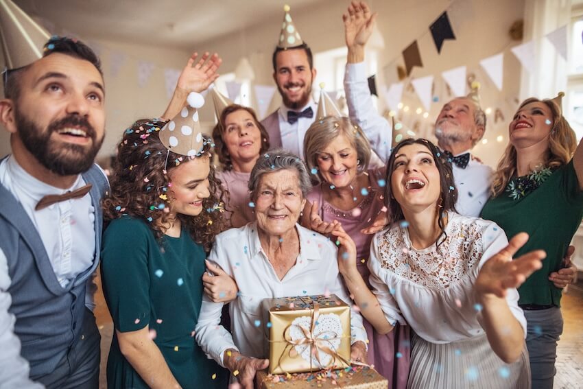 Birthday card ideas for grandma: senior woman happily celebrating her birthday with her family