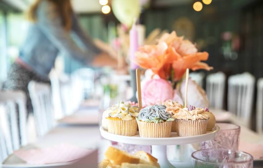 Baby in bloom baby shower: table setting with cupcakes and flowers