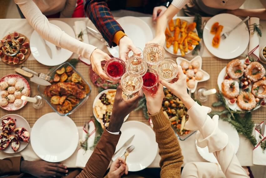 Christmas dinner invitation: top view of people clinking their glasses