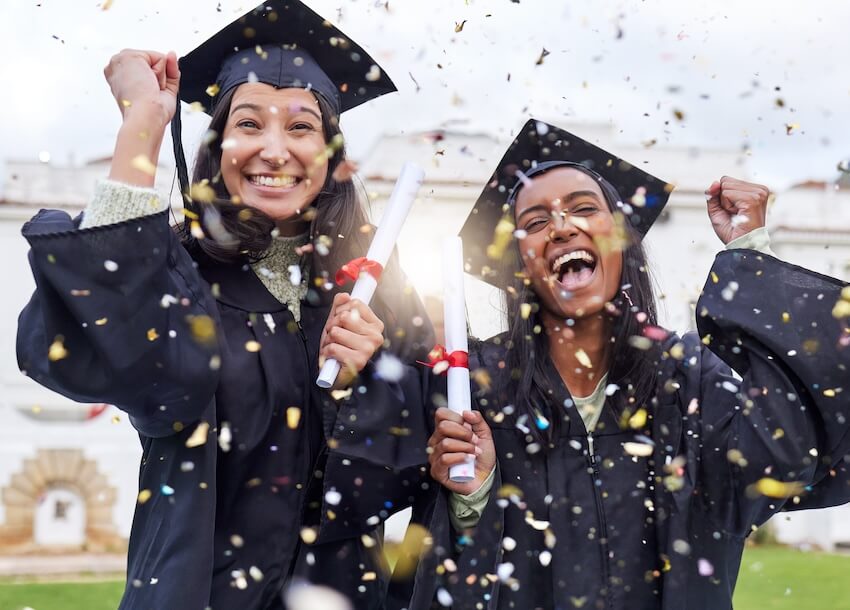 Sweet graduation messages: two graduates excitedly celebrating while confetti falls around them