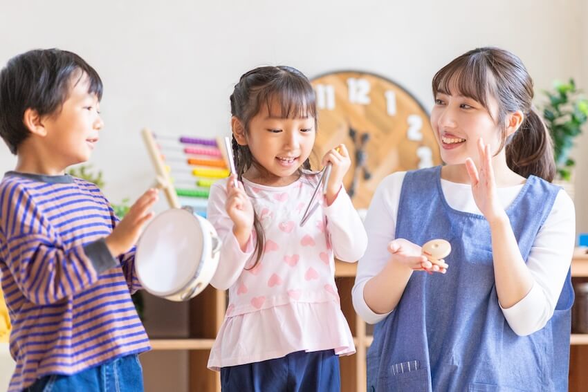 Two kids and their teacher playing instruments