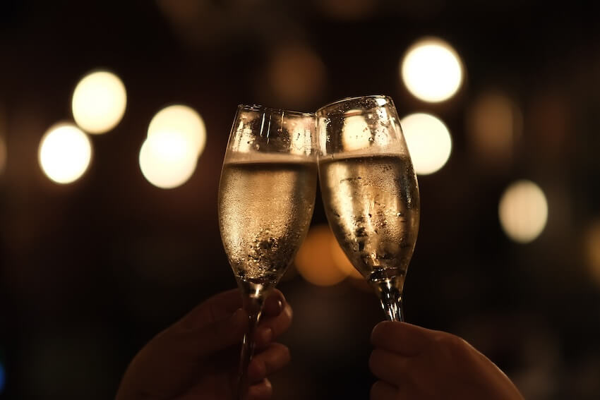 Two people clinking their champagne glasses