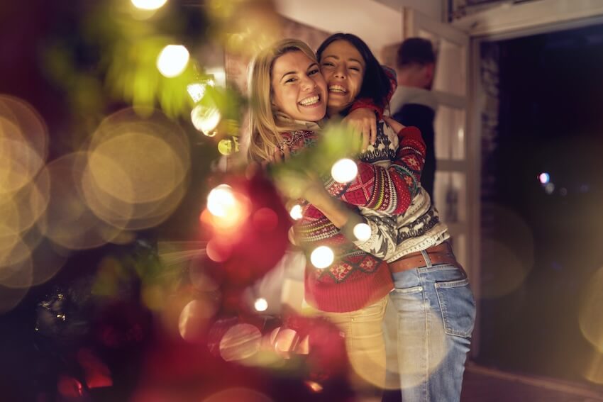 Friendsmas invitation: two women hugging each other