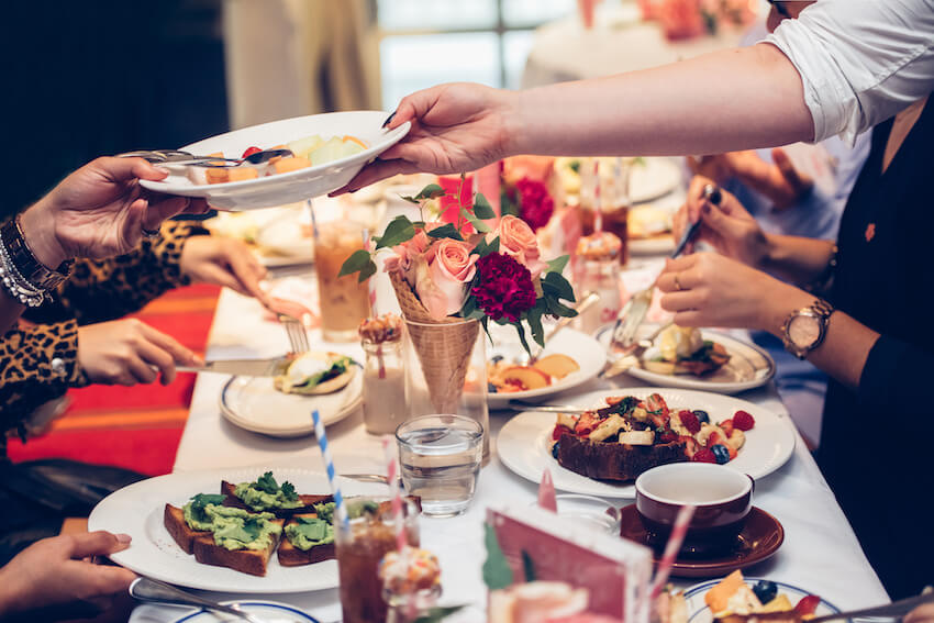 Bridal shower brunch ideas: waiter handing a bowl of food to a customer