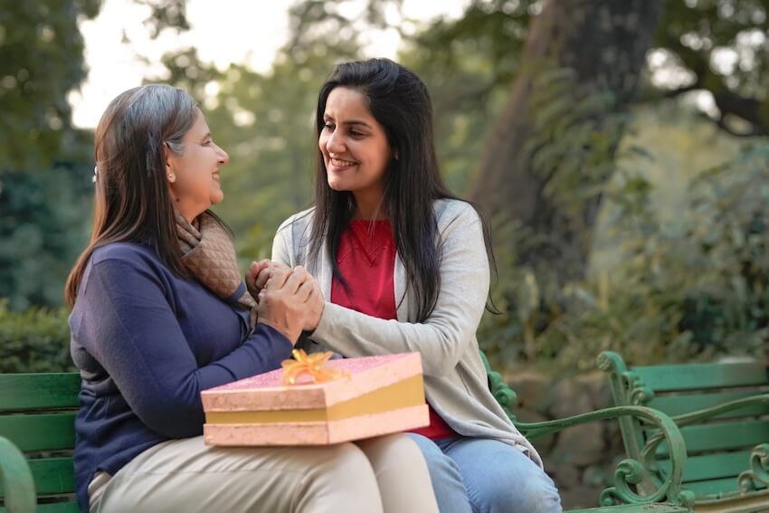Happy birthday mother in law: woman giving a gift to her mother in law