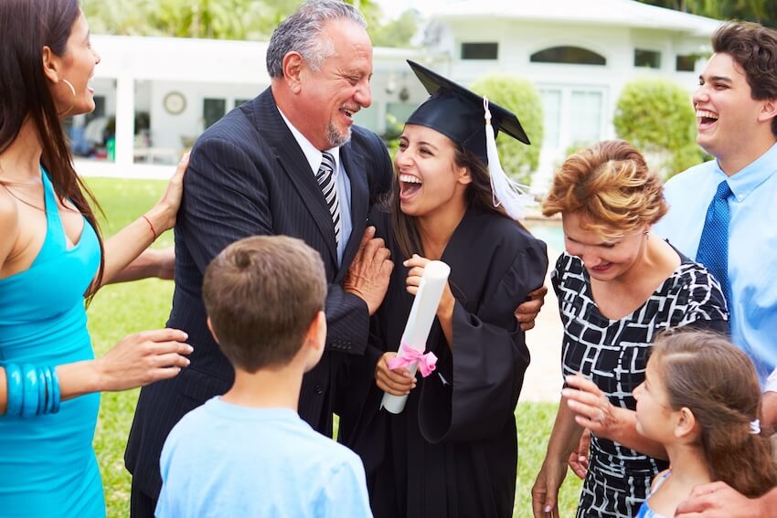 Graduation announcement cards: woman happily celebrating her graduation with her family