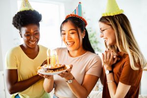 Happy birthday sweet friend: woman happily holding her birthday cake