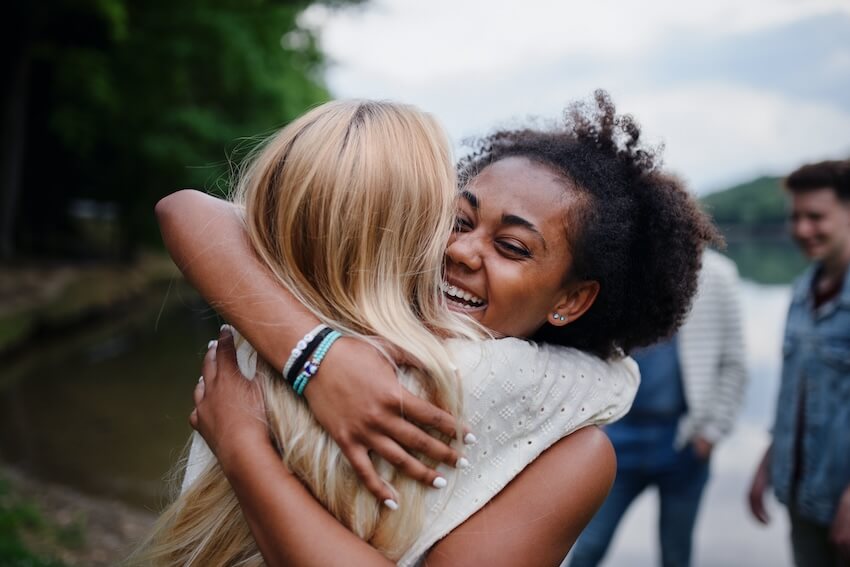 Thank you note for party host: woman happily hugging her friend