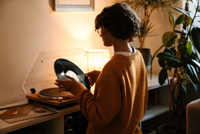 Woman putting a vinyl record into a turntable