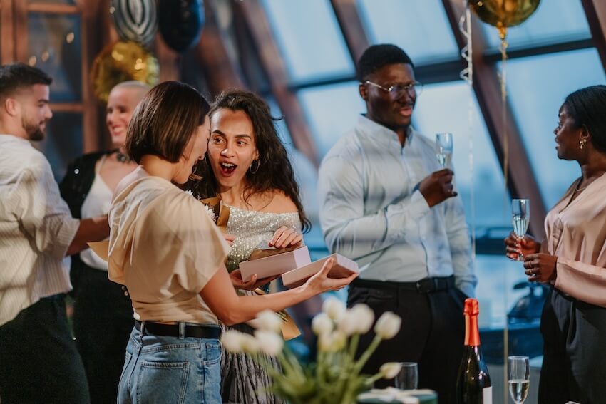 30th birthday gift ideas: woman receiving a gift at a party