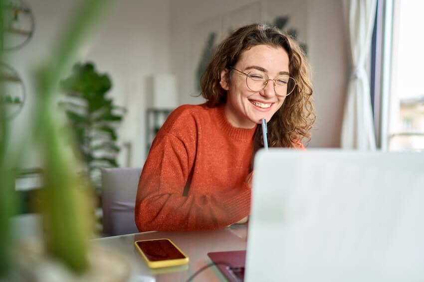 Anniversary ecard: woman wearing a pair of eyeglasses, happily looking at her laptop